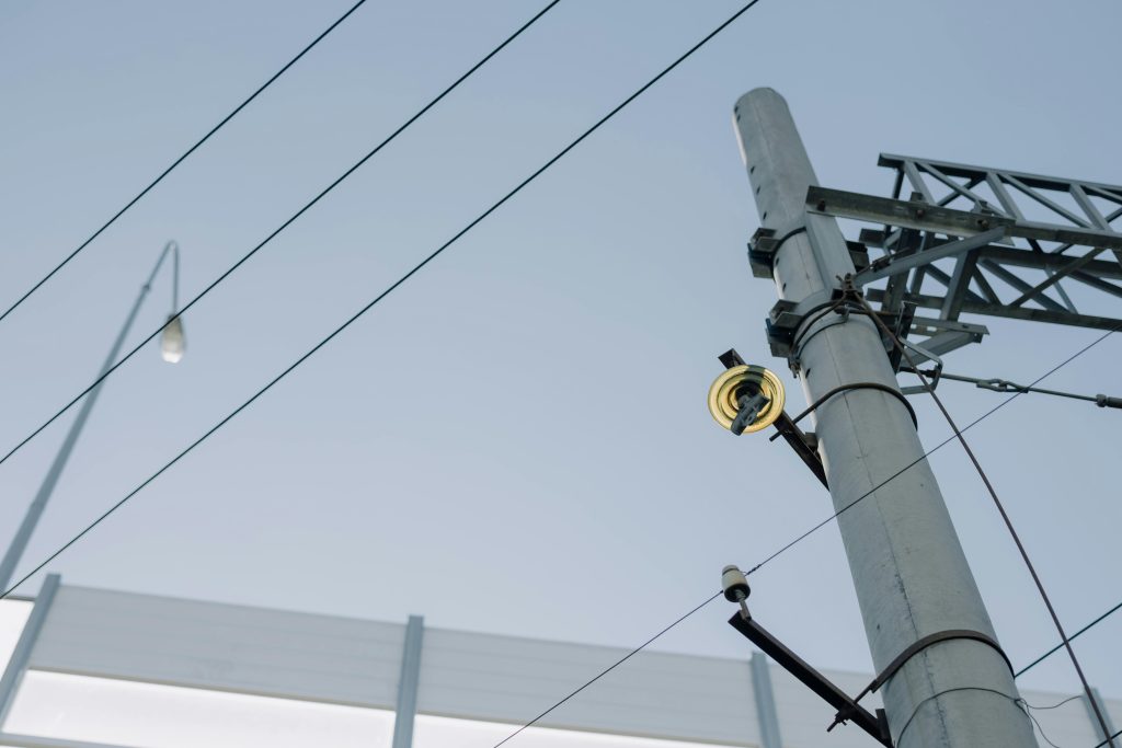 What We Believe 5 Utility pole with electrical wires and equipment against a clear blue sky, showcasing urban infrastructure.